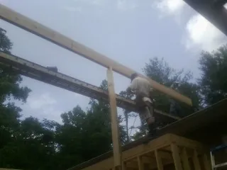 Carpenter setting a ridge beam over a new addition frame — Ice Dam Removal by Roofing Brothers in Gunpowder