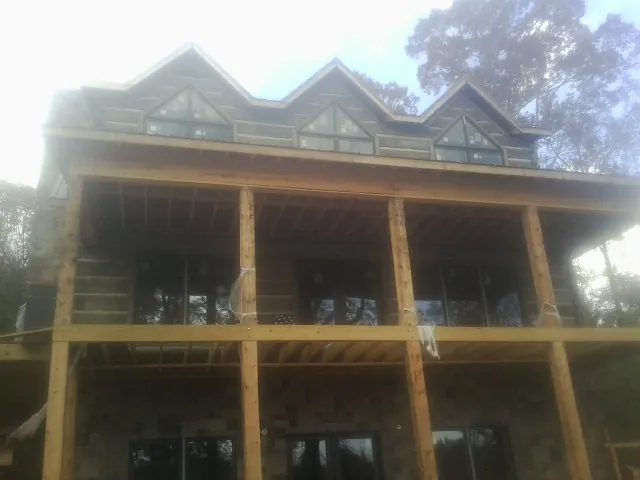 Dormers and porch framing on a large log home under construction — Roof Coating work by our crew in Gunpowder