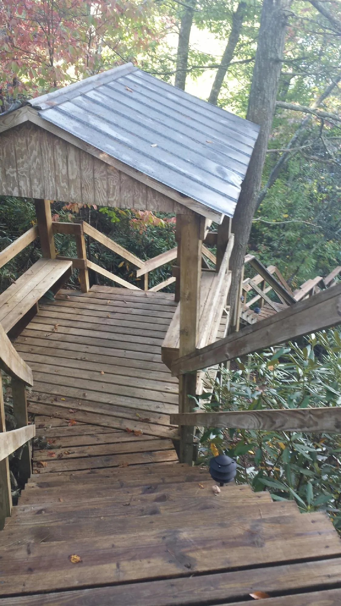 Metal roofed shelter over wooden steps on a wooded walkway — Skylight Repair & Installation work by our crew in Gunpowder