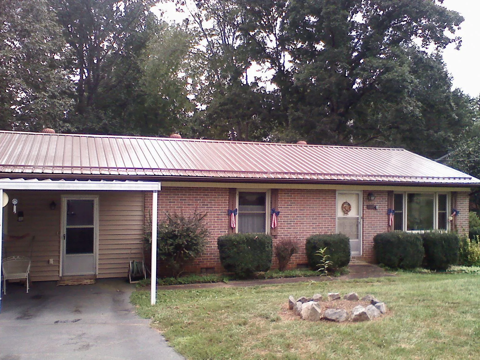 Bronze metal roof and carport on a brick ranch home — Roof Repair work by our crew in Gunpowder