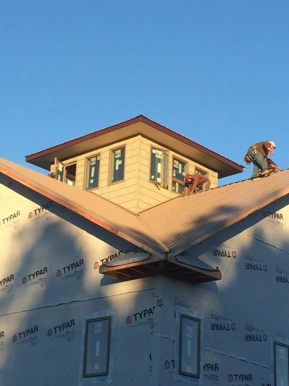 Roofers working around a rooftop cupola on a new metal roof at sunset — Roof Waterproofing in Gunpowder by Roofing Brothers